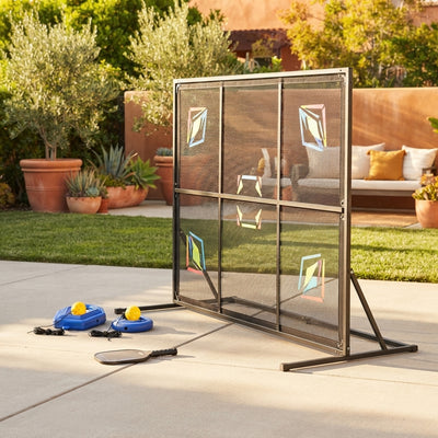 Pickleball rebounder training board positioned on a suburban driveway with terracotta and amber accents in the background.